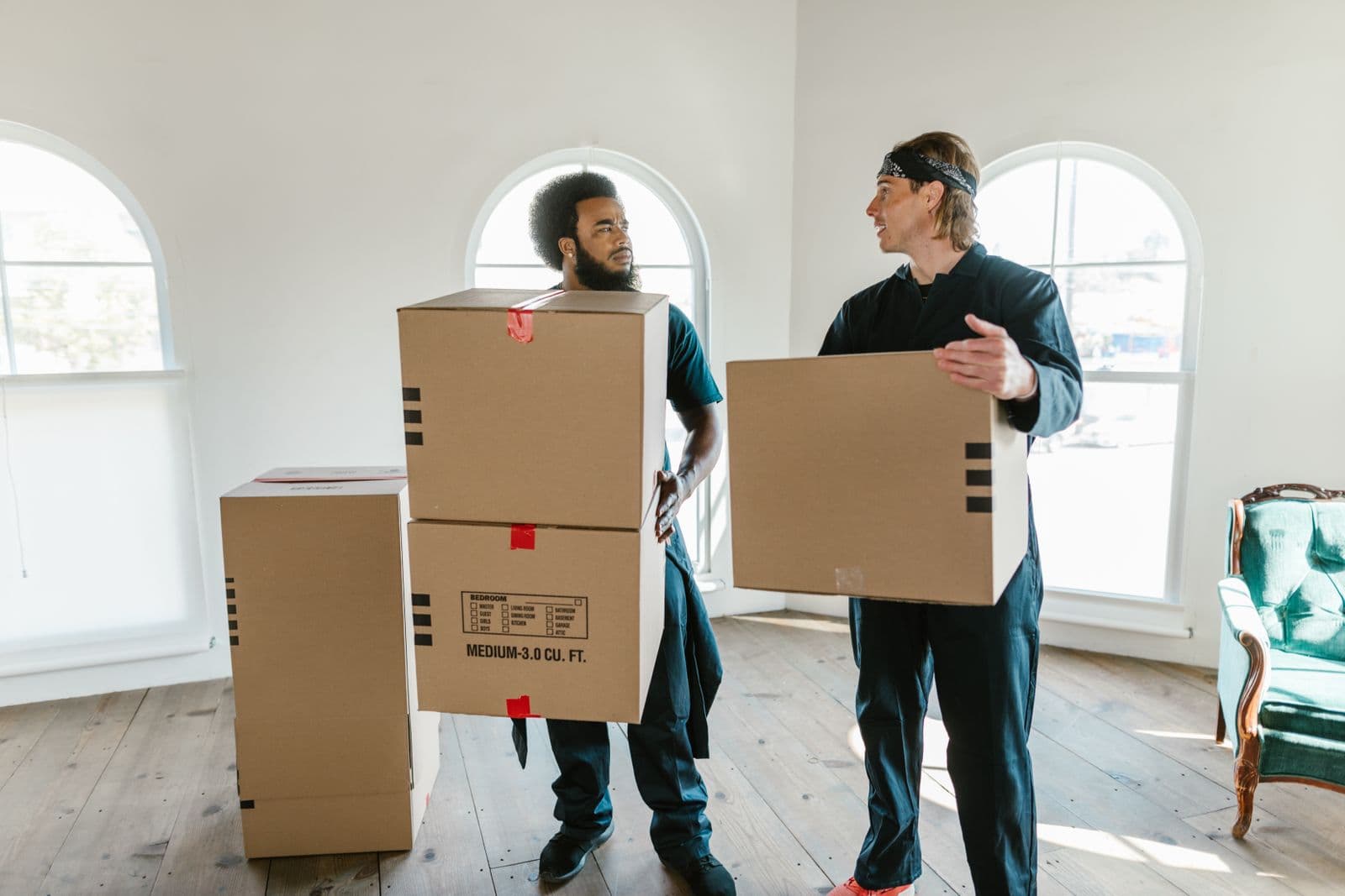 Professional movers carrying boxes in a bright South Florida home